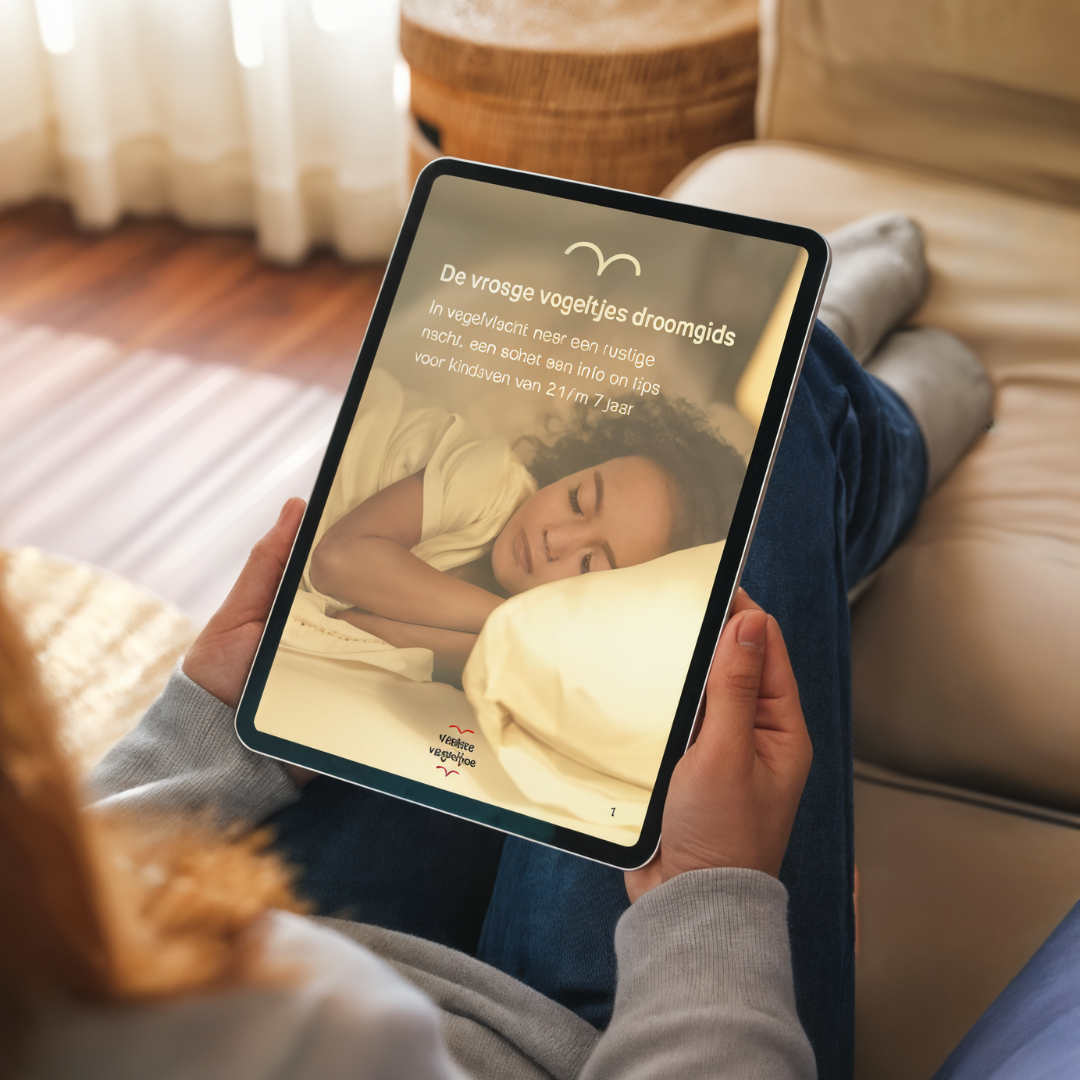 Ouder op bank die tablet vast heeft en droomgids e-book leest
