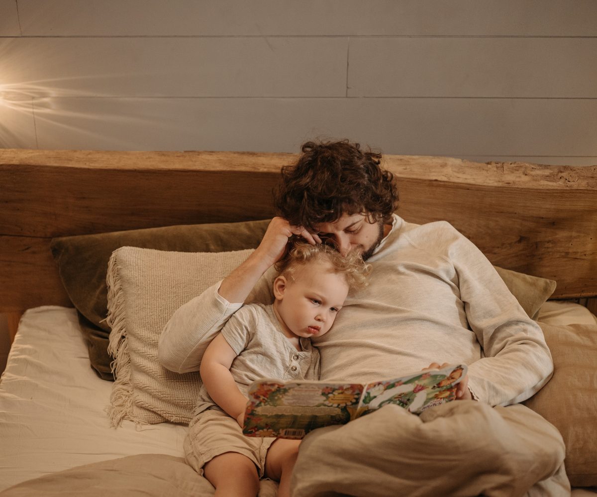 Vader leest samen met zijn kind voor in bed